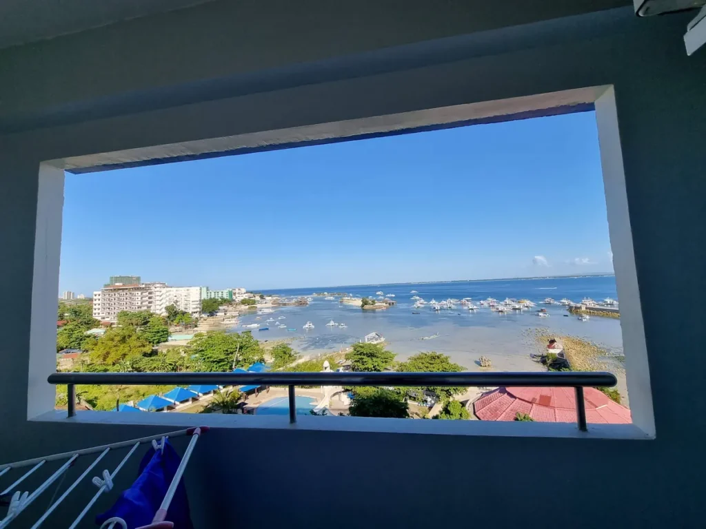 필리핀 세부 블루오션(BLUEOCEAN) 어학원 3인 오션뷰 객실 창 너머로 보이는 항구와 바다, 리조트 수영장 풍경