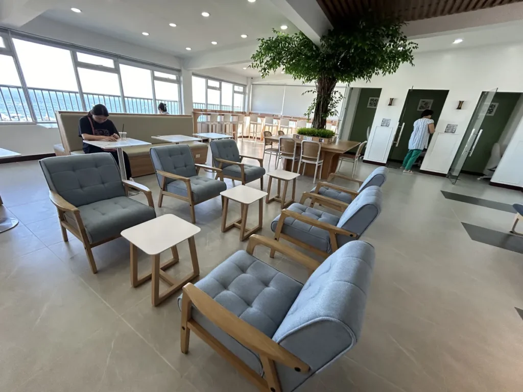 필리핀 세부 블루오션(BLUEOCEAN) 어학원 라운지로 바다 전망 창가에 대리석 테이블과 화이트보드형 좌석이 놓인 코너 공간입니다