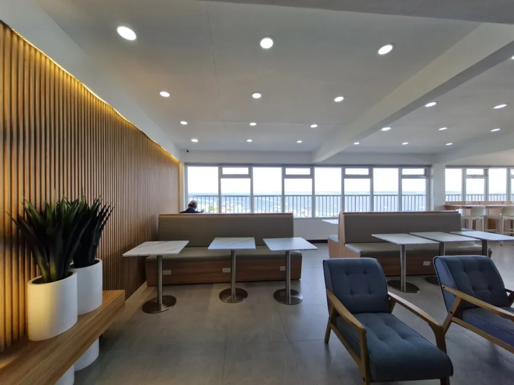 필리핀 세부 블루오션(BLUEOCEAN) 어학원 라운지로 바다가 보이는 창가 우드 카운터에 흰 바 스툴이 배치된 채광 좋은 좌석 공간입니다