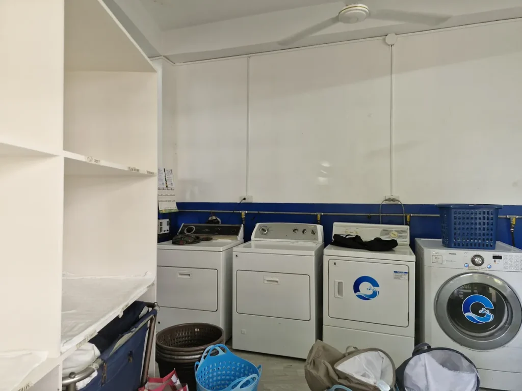 필리핀 세부 블루오션(BLUEOCEAN) 어학원 부대시설 세탁실의 일렬 세탁기와 건조기, 수납 선반