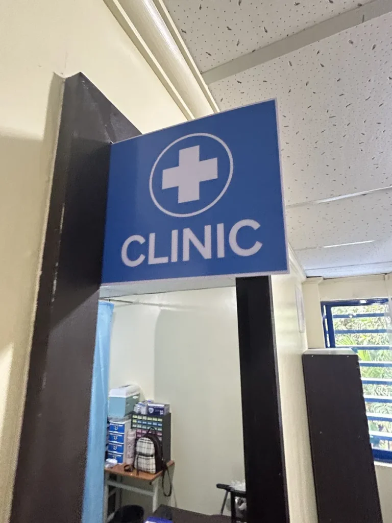 필리핀 세부 블루오션(BLUEOCEAN) 어학원 의무실 입구에 걸린 파란 십자 CLINIC 간판과 의약품이 보이는 진료실 내부