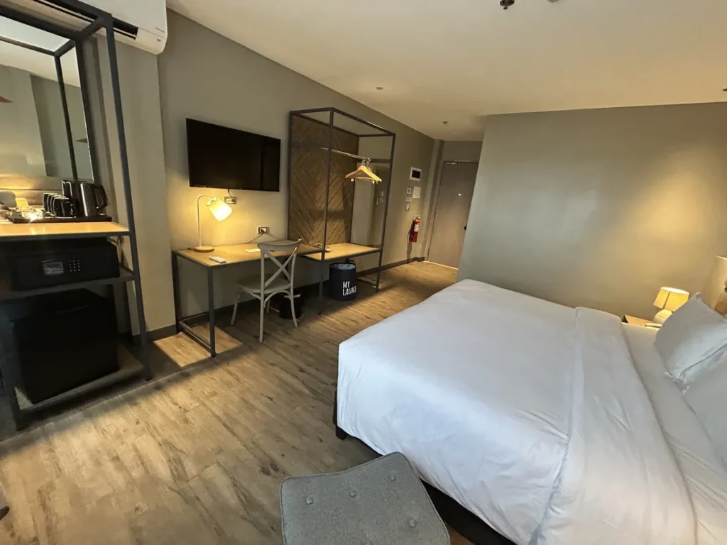 필리핀 세부 블루오션(BLUEOCEAN) 어학원 외부기숙사 1인실 오션뷰의 침대와 책상, 행거가 보이는 전체 모습