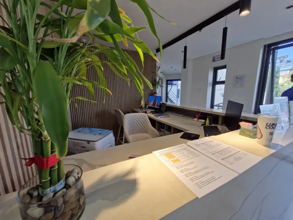 필리핀 세부 블루오션(BLUEOCEAN) 어학원 외부숙소 로비 리셉션 카운터와 행운목 화분이 놓인 안내 데스크 모습