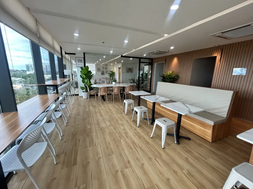 필리핀 세부 블루오션(BLUEOCEAN) 어학원 외부숙소 부대시설로, 창가 바 테이블과 대리석 무늬 테이블·벤치가 배치된 밝은 스카이라운지 학습 겸 휴게 공간입니다.
