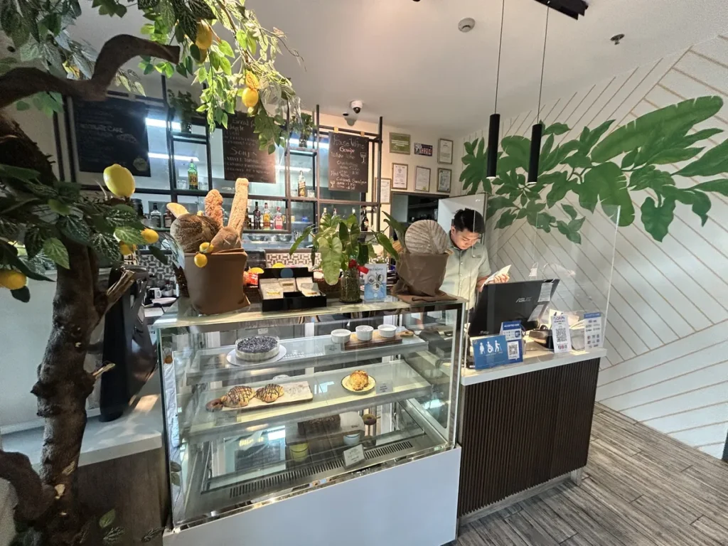 필리핀 세부 블루오션(BLUEOCEAN) 어학원 외부숙소 부대시설로, 케이크 쇼케이스와 메뉴판이 놓인 카페 카운터입니다.