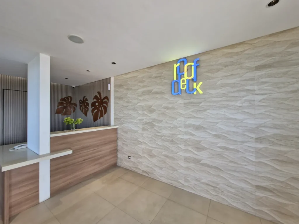 필리핀 세부 블루오션(BLUEOCEAN) 어학원 외부숙소 루프덱 입구로, 몬스테라 장식과 리셉션 데스크, roof deck 사인이 있는 공간입니다.
