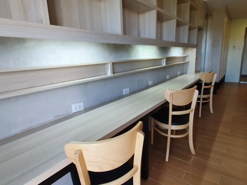 필리핀 세부 CIA어학원 3인실 침대 머리맡으로 그림 액자와 벽등, 우드톤 헤드보드가 보입니다.