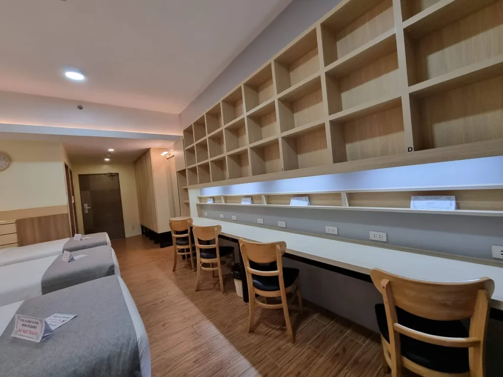 필리핀 세부 CIA어학원 4인실로 침대 맞은편에 긴 공용 책상과 의자, 개인 수납 칸이 벽면을 따라 마련돼 있다.