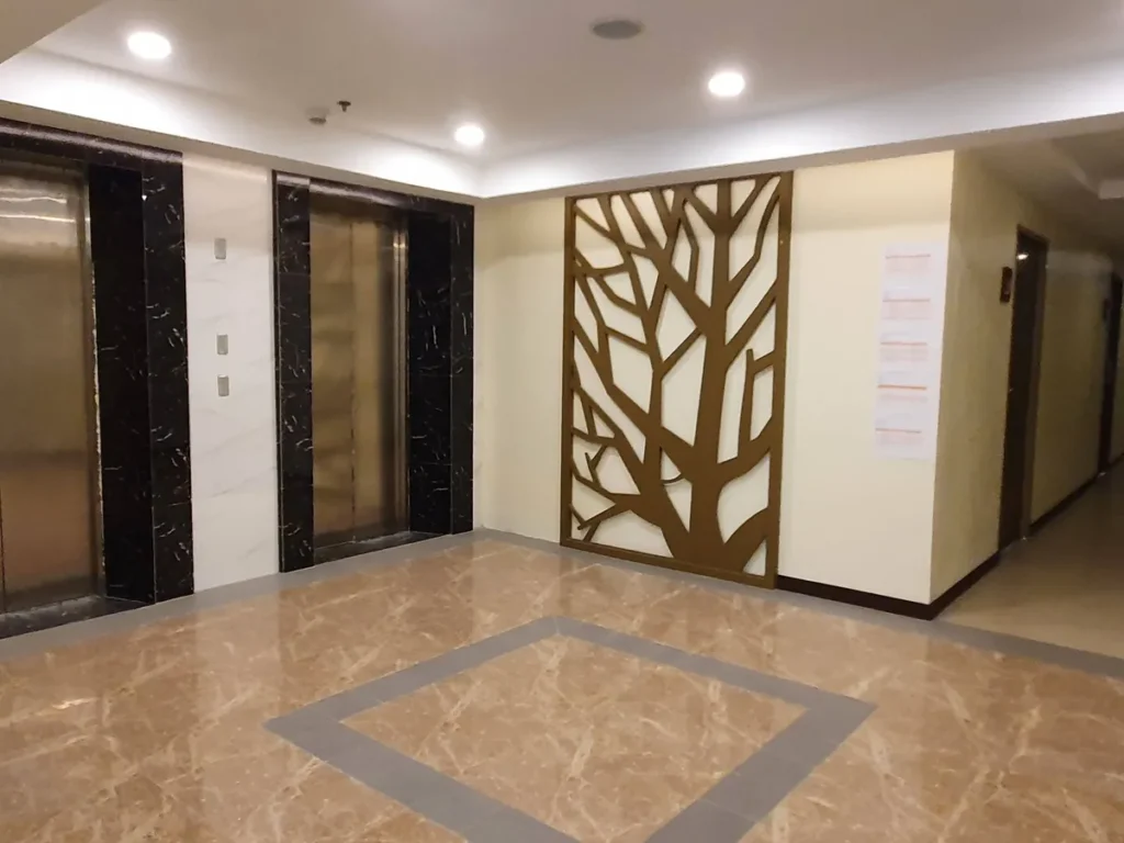 필리핀 세부 CIA어학원 내부 기숙사 엘리베이터 홀의 대리석 바닥과 나무 장식 벽 모습