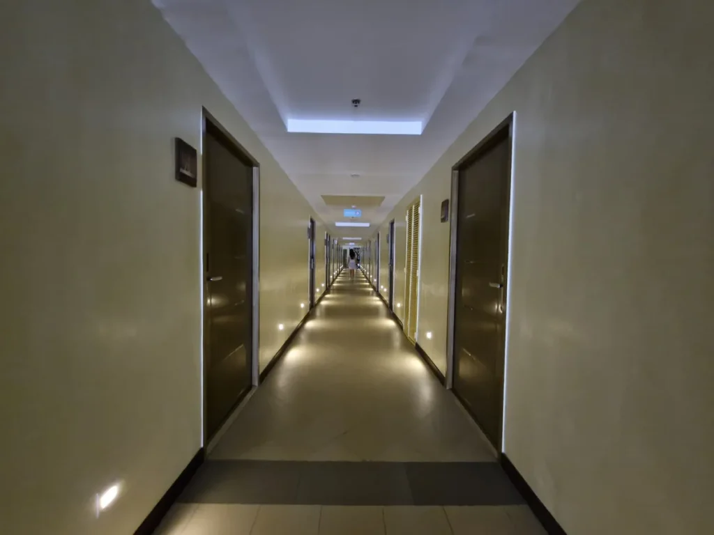 필리핀 세부 CIA어학원 내부 기숙사 양옆 객실 문 사이로 길게 이어진 어두운 복도 모습