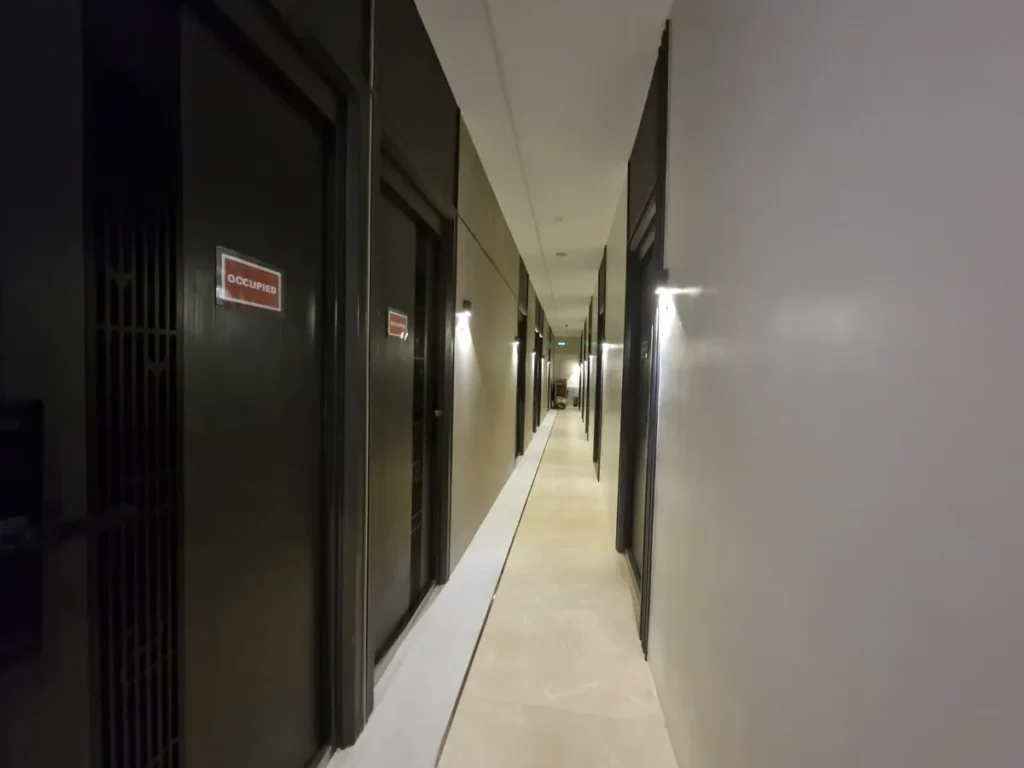 필리핀 세부 CIA어학원 외부 숙소의 어두운 객실 문이 늘어선 호텔형 복도 모습