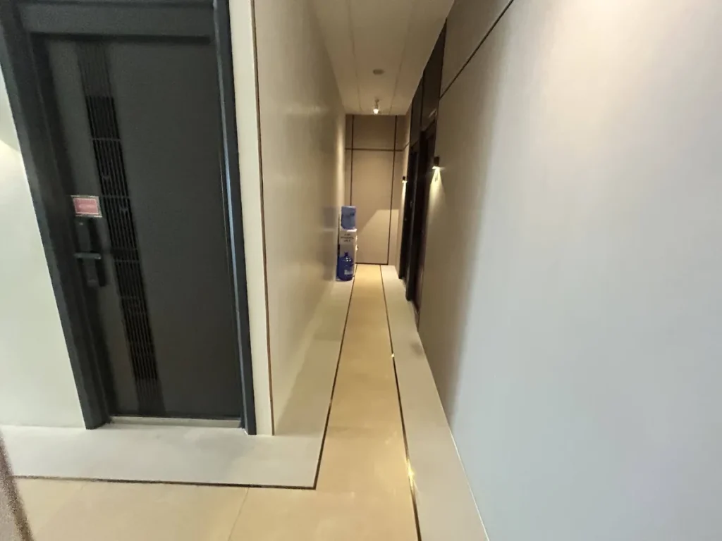 필리핀 세부 CIA어학원 외부 숙소 객실 문과 밝은 타일 바닥이 이어지는 복도 모습