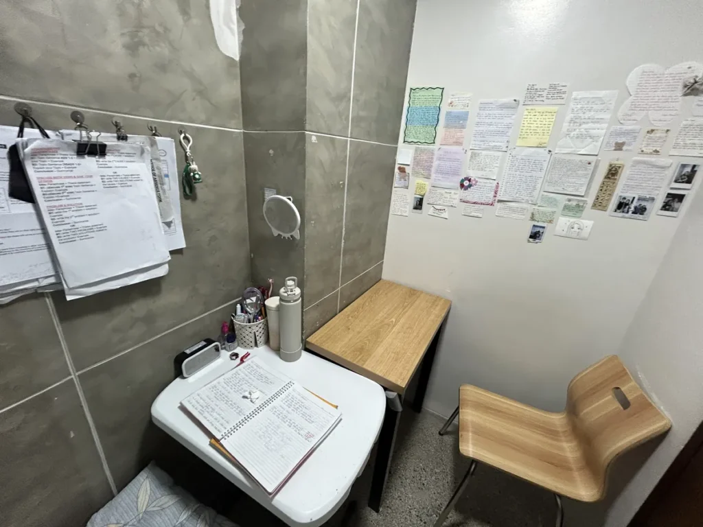 필리핀 세부 CIA어학원 1대1 수업실, 벽에 학생 편지와 학습 자료를 붙여 둔 코너 책상과 의자가 있는 부스입니다.