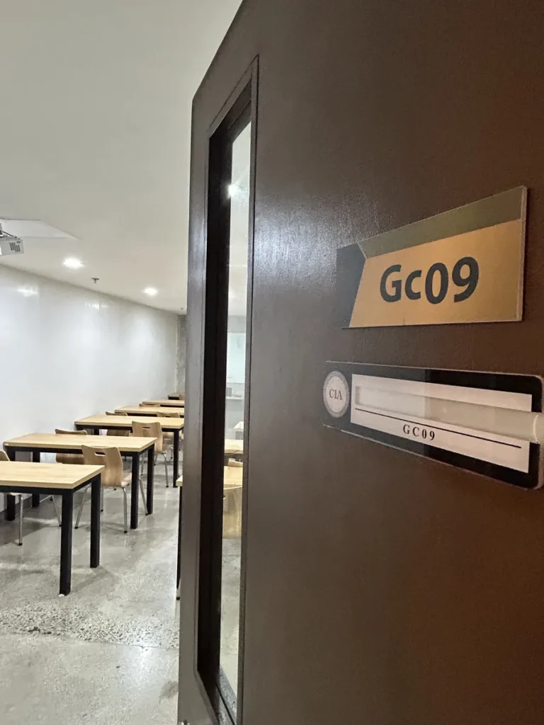 필리핀 세부 CIA어학원 그룹 강의실, 강의실 문에 붙은 Gc09 호실 표지판과 안쪽 책상들이 보입니다.