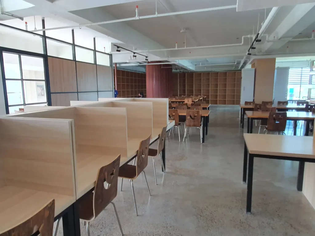 필리핀 세부 CIA어학원 자습실 한쪽 붉은 세로살 칸막이 벽 앞에 책상과 의자가 모여 있습니다.