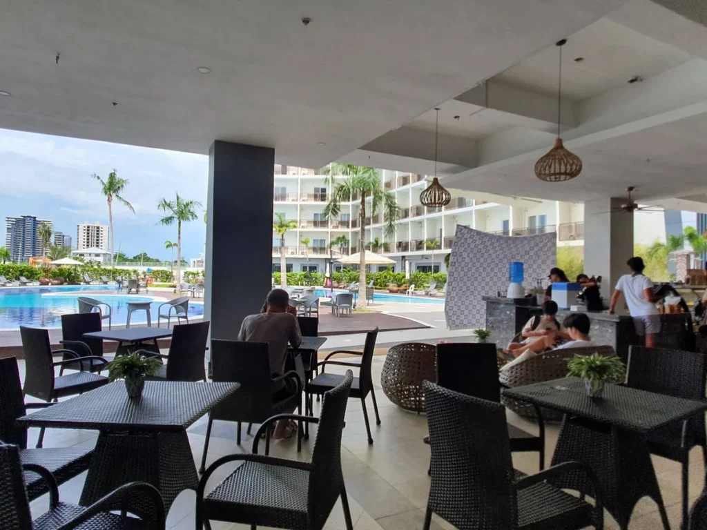 필리핀 세부 CIA어학원 라운지 및 카페, 라탄 펜던트 조명 아래 라탄 소파와 테이블이 배치된 야외 라운지 공간