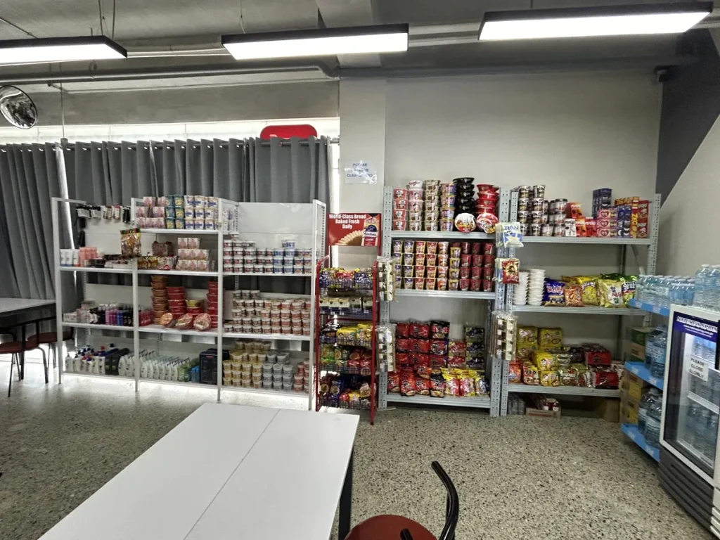 필리핀 세부 CIA어학원 매점 통조림과 식료품 진열대, 옆에 테이블이 놓인 넓은 매장 모습