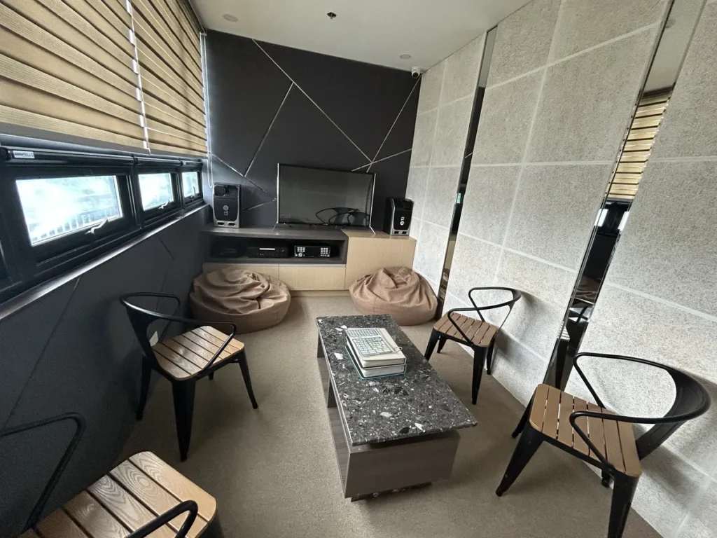 필리핀 세부 CIA어학원 노래방으로 TV와 빈백, 의자가 놓인 좌식 테이블이 차분한 톤으로 꾸며진 공간