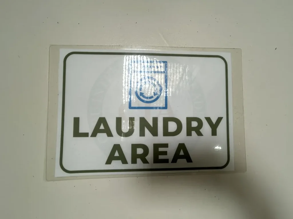 필리핀 세부 CIA어학원 세탁실, 벽에 부착된 세탁 구역(Laundry Area) 안내 표지판을 가까이서 보여 줍니다.
