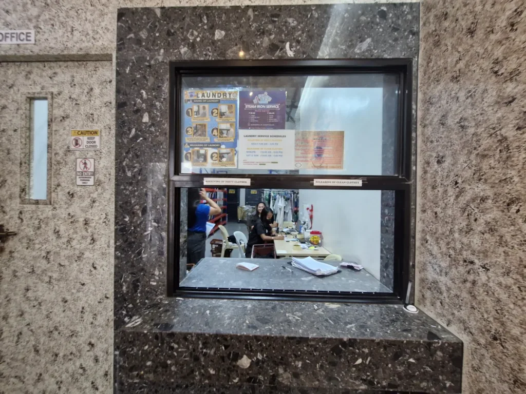 필리핀 세부 CIA어학원 세탁실, 대리석 마감 벽에 설치된 세탁물 접수 창구를 정면에서 본 모습입니다.