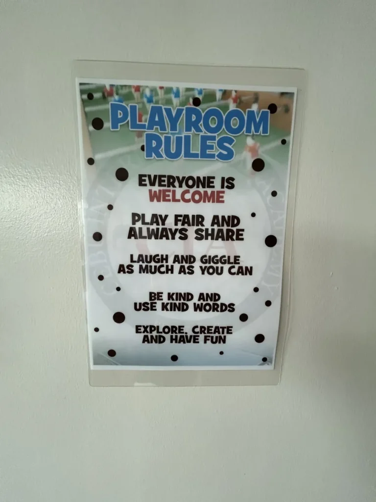 필리핀 세부 CIA어학원 부대시설 안내판으로, 함께 나누고 즐기자는 문구를 담은 PLAYROOM RULES 안내문이 흰 벽에 부착되어 있습니다.