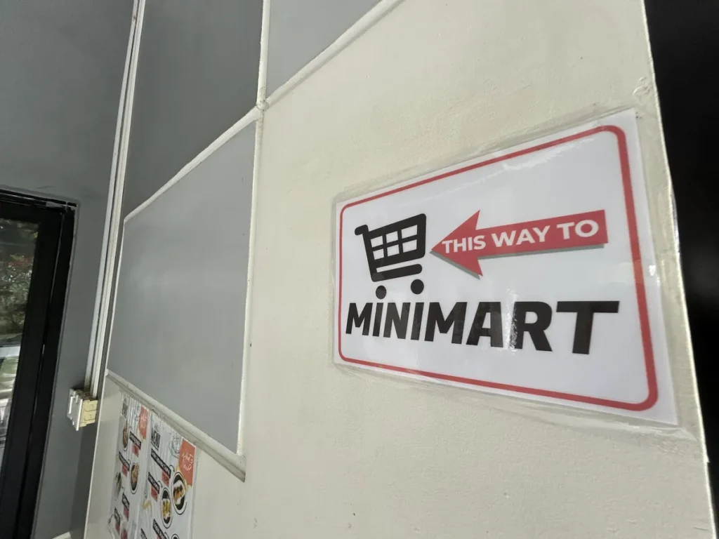 필리핀 세부 CIA어학원 부대시설 안내판으로, 미니마트 방향을 가리키는 THIS WAY TO MINIMART 표지판이 복도 벽에 부착되어 있습니다.