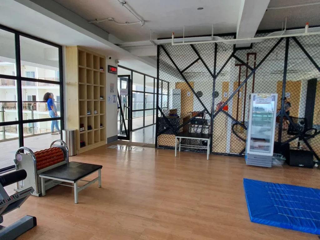 필리핀 세부 CIA어학원 헬스장 입구 쪽으로 신발 보관 칸과 디지털 시계가 있고 옆에 그물망 칸막이 공간이 보인다.