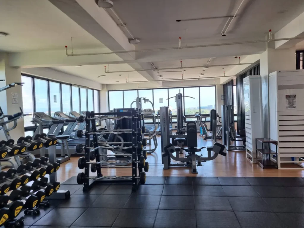 필리핀 세부 CIA어학원 헬스장 내부로 덤벨 랙과 바벨, 머신형 웨이트 기구가 창가를 따라 줄지어 놓여 있다.