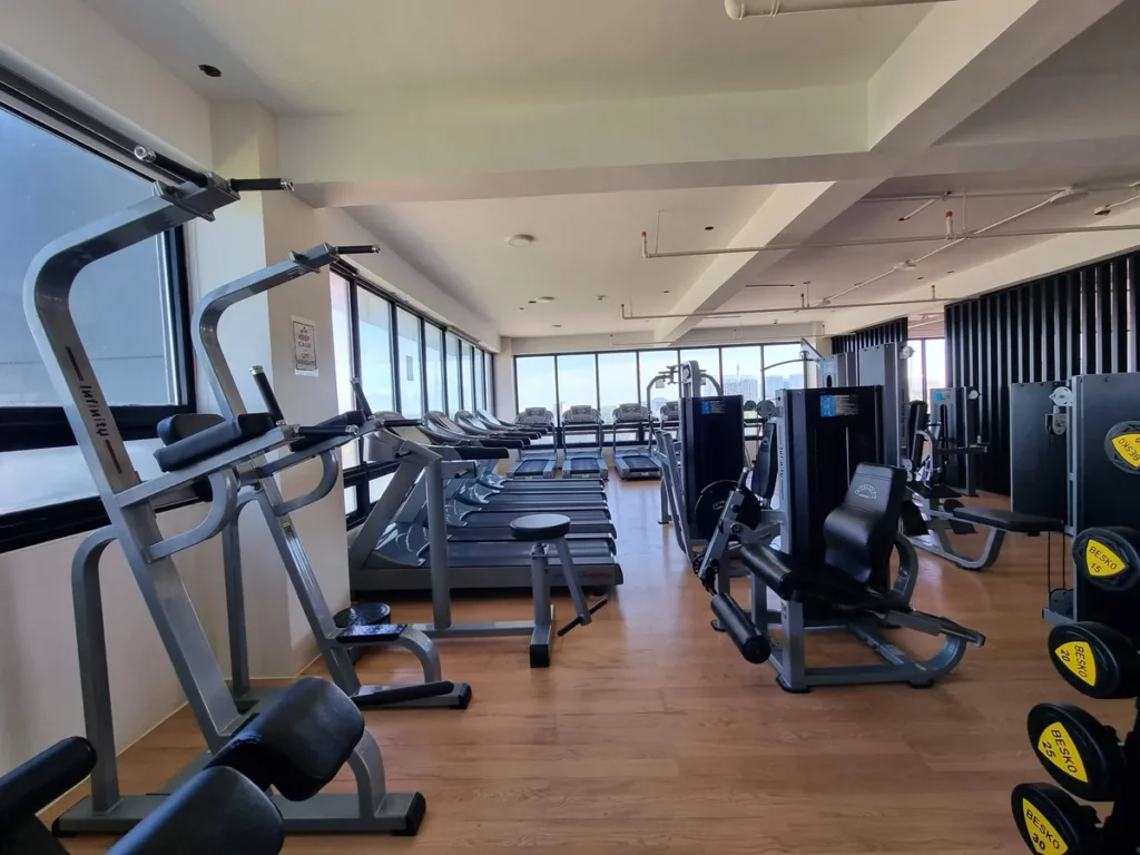 필리핀 세부 CIA어학원 헬스장 러닝머신 구역으로 창가를 따라 트레드밀이 늘어서 있고 옆에 레그 프레스 등 머신이 있다.