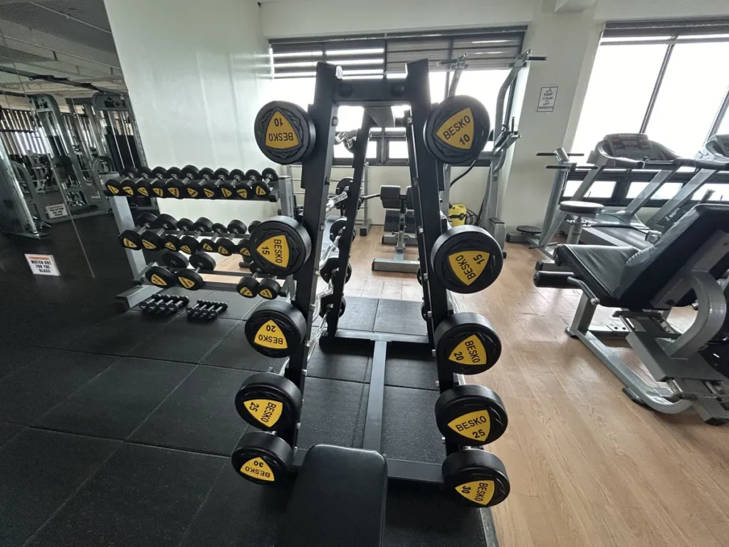 필리핀 세부 CIA어학원 헬스장 베스코 덤벨과 바벨 랙이 정리돼 있고 옆으로 벤치와 트레드밀이 놓여 있다.