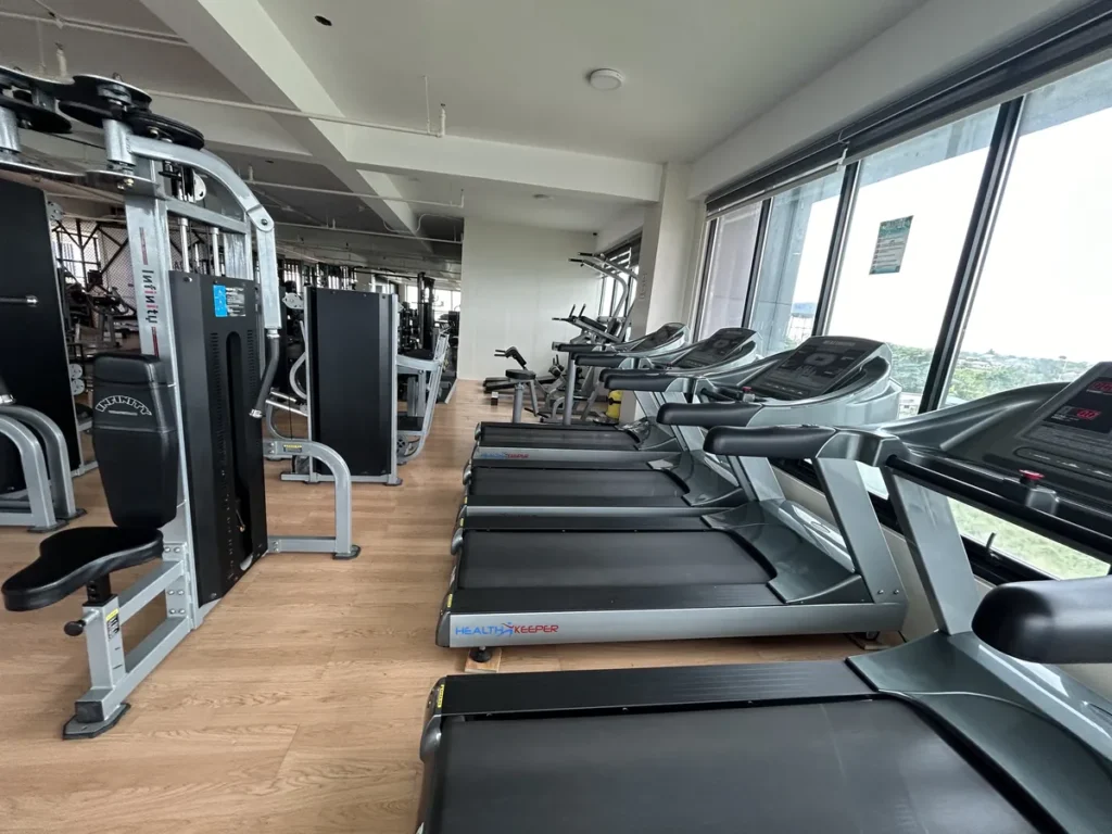 필리핀 세부 CIA어학원 헬스장으로 일렬로 놓인 러닝머신과 인피니티 머신형 기구가 우드 바닥 위에 배치돼 있다.
