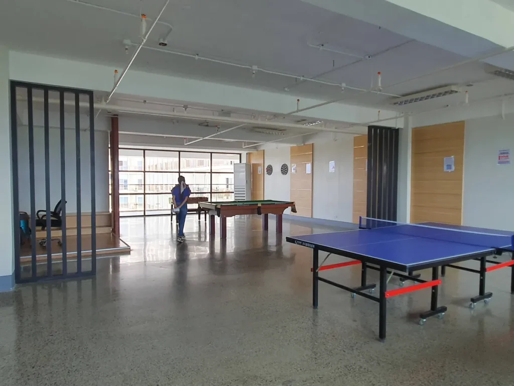 필리핀 세부 CIA어학원 탁구장으로 파란 탁구대 한 대와 안쪽 녹색 당구대, 다트판, 통유리창 너머 전망이 보인다
