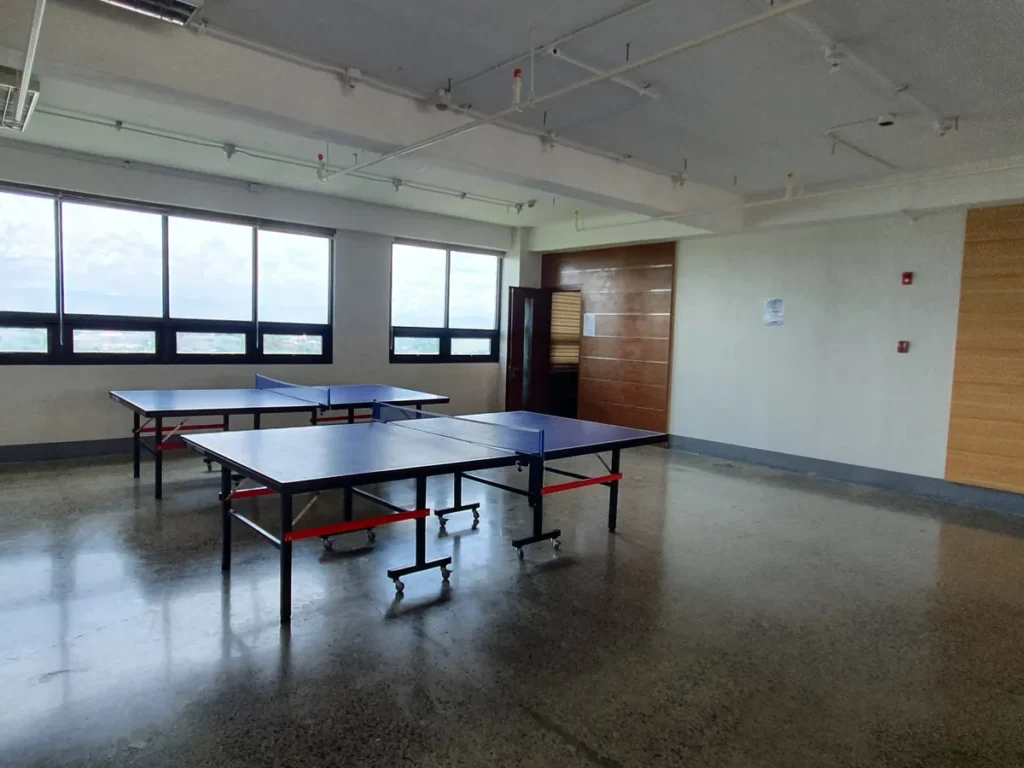 필리핀 세부 CIA어학원 탁구장에 파란 탁구대 두 대가 놓이고 창문과 우드 패널 벽이 있는 실내 모습