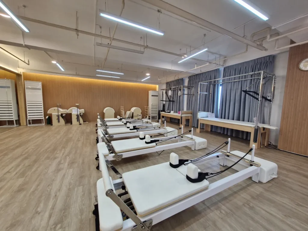 필리핀 세부 CIA어학원 요가 및 필라테스 룸 커튼 벽 앞 리포머와 체어 기구