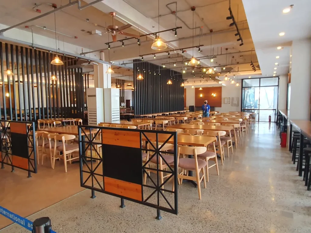 필리핀 세부 CIA어학원 식당 입구 쪽 바 테이블, 통유리 너머 야자수와 야외 테라스 좌석이 보이는 통로