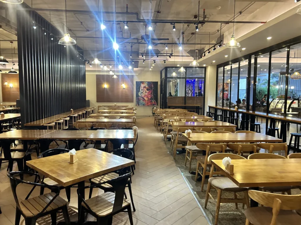 필리핀 세부 CIA어학원 식당 야간 모습, 격자 칸막이와 창가를 따라 원목 식탁이 놓인 실내