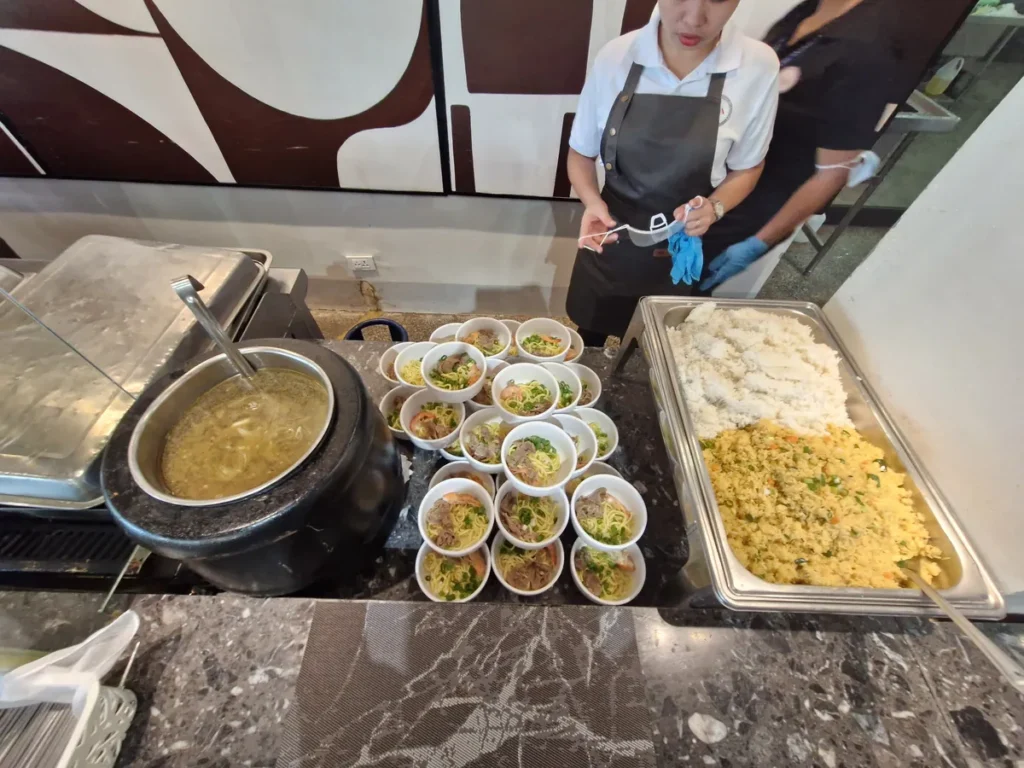 필리핀 세부 CIA어학원 식당에서 직원이 솥국과 함께 새우·고기 올린 국수 1인 그릇과 볶음밥을 차리는 모습