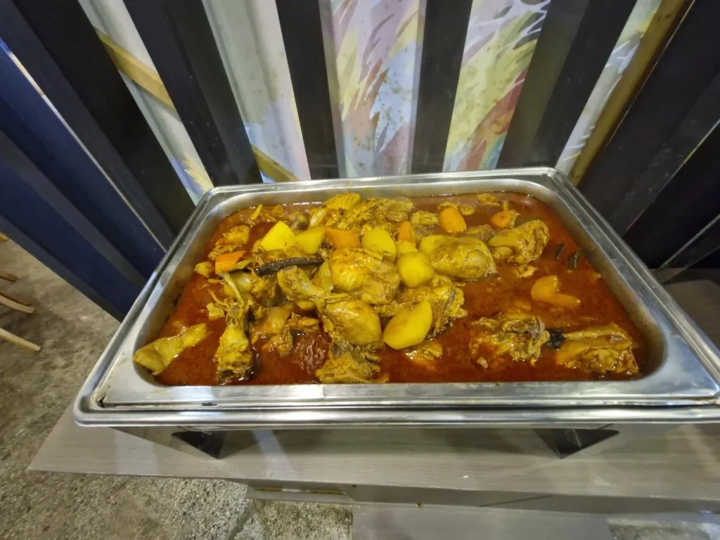 필리핀 세부 CIA어학원 식당 배식대에 당근과 감자를 넣어 붉게 조린 닭볶음탕이 큰 트레이에 담긴 모습