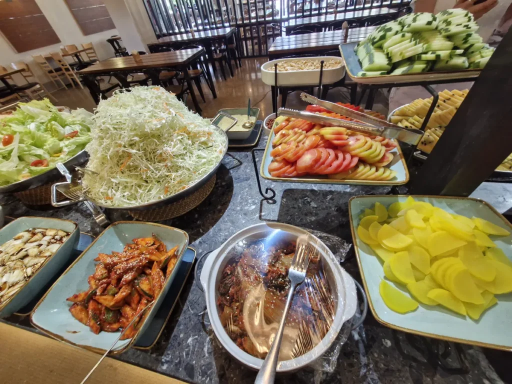 필리핀 세부 CIA어학원 식당 반찬대에 양배추 샐러드, 토마토, 매콤 무침, 단무지 등 여러 반찬을 차린 모습