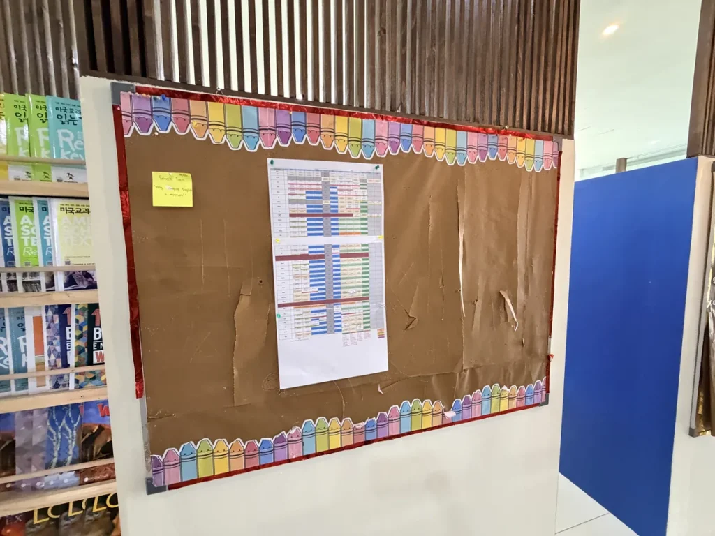 필리핀 세부 EDUTALK어학원 시간표 게시판과 원서 책장이 있는 복도