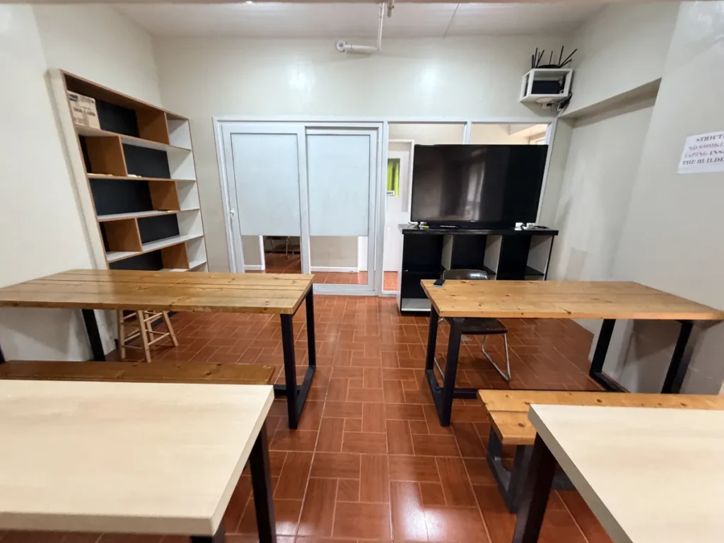 필리핀 바기오 MONOL어학원 그룹 수업실 책상과 모니터 책장