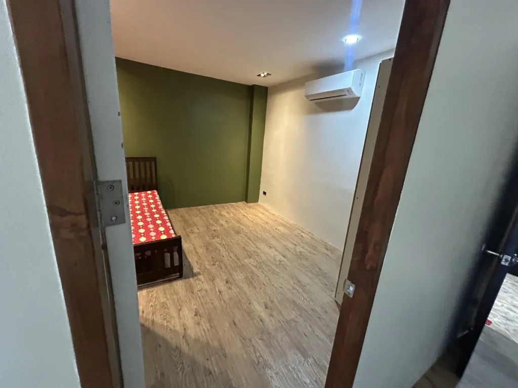 필리핀 막탄 IZAM어학원 기숙사 문틈으로 본 침대와 에어컨 침실