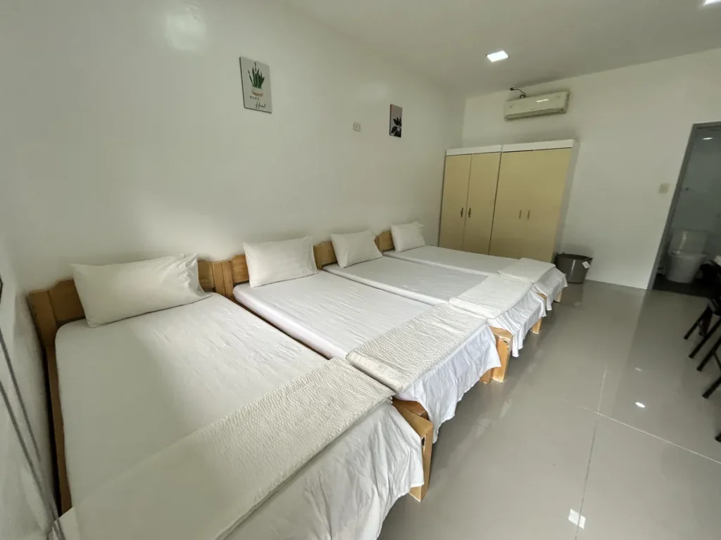 필리핀 클락 벨라(BELA) 어학원 기숙사 4인실로, 원목 침대 네 개가 나란히 붙어있고 크림색 옷장과 에어컨, 개별 화장실이 딸린 방입니다.