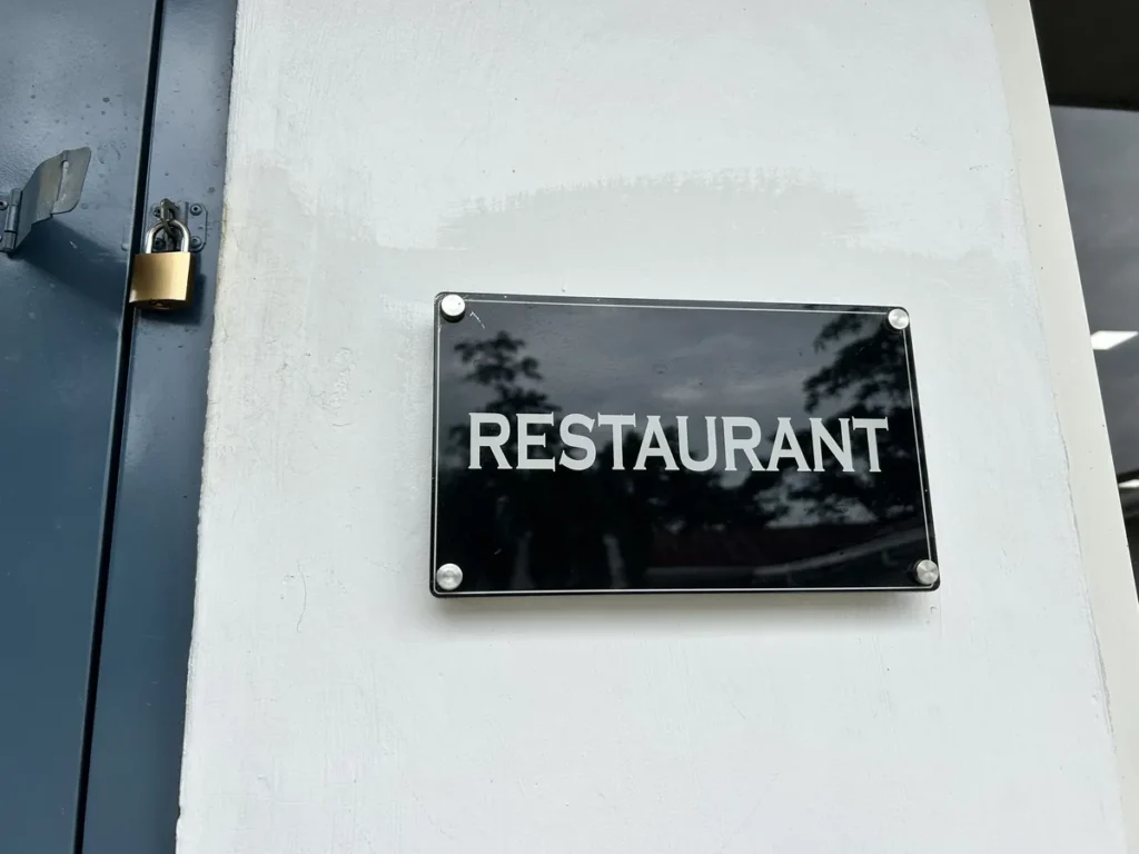 필리핀 클락 벨라(BELA) 어학원 식당으로, 자물쇠 걸린 문 옆 흰 벽에 RESTAURANT라고 적힌 검정 안내판이 붙어 있는 모습입니다.