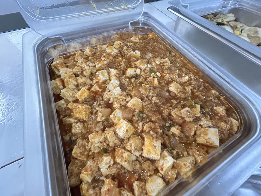 필리핀 클락 벨라(BELA) 어학원 식당 식사로, 배식통에 두부와 다짐육 소스가 섞인 마파두부 반찬이 가득 담겨 있습니다.
