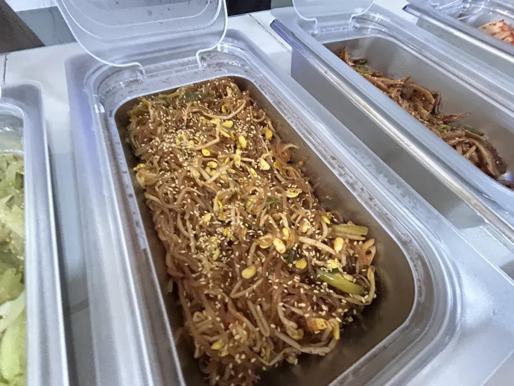 필리핀 클락 벨라(BELA) 어학원 식당 식사로, 배식통에 당면과 콩나물, 땅콩·참깨를 곁들인 잡채풍 반찬이 담겨 있습니다.