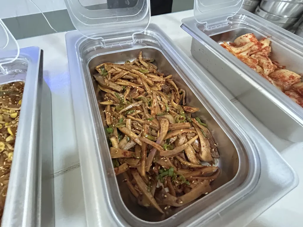 필리핀 클락 벨라(BELA) 어학원 식당 식사로, 배식통에 참깨와 대파를 곁들인 우엉조림 옆으로 배추김치가 함께 놓여 있습니다.