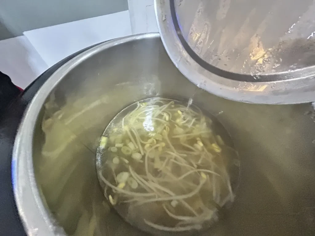 필리핀 클락 벨라(BELA) 어학원 식당 식사로, 큰 솥에서 콩나물국이 김을 내며 끓고 있는 조리 장면입니다.