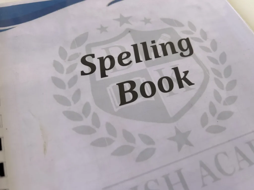 필리핀 세부 바나나키즈(BK) 어학원 강의실 교재로, BK 학원 엠블럼이 새겨진 Spelling Book 표지를 가까이서 담은 모습입니다.