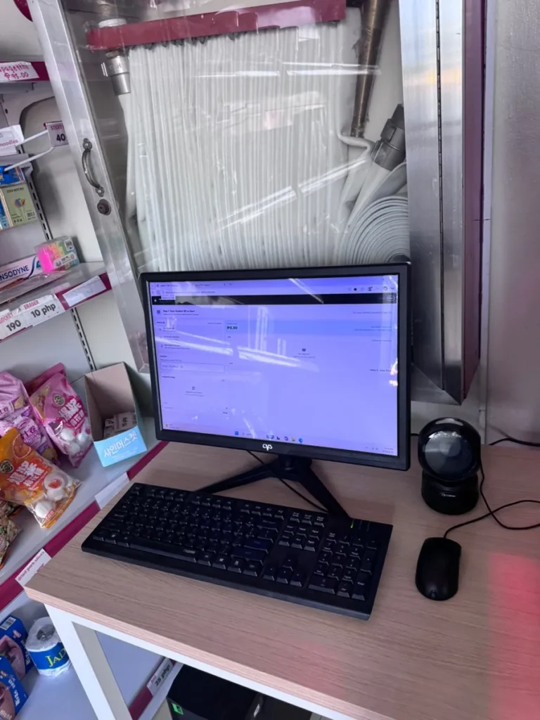 필리핀 세부 셀라(CELLA) 유니캠퍼스 어학원 부대시설 매점으로, 모니터와 키보드, 바코드 스캐너가 놓인 매점 계산대입니다.